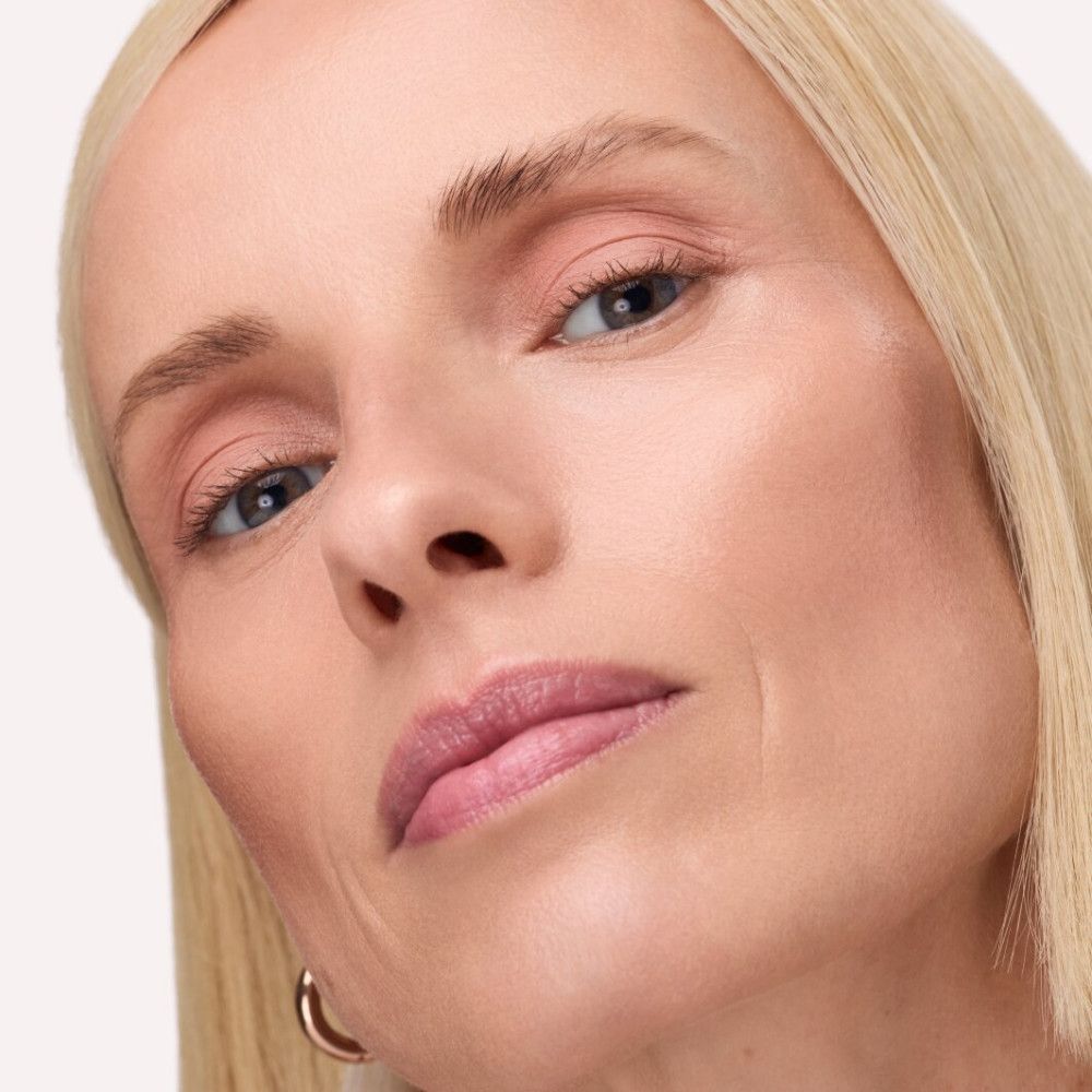Nahaufnahme eines Gesichts. Aufgetragenes rosa Lidschatten. Blonde Haare, helle Haut.