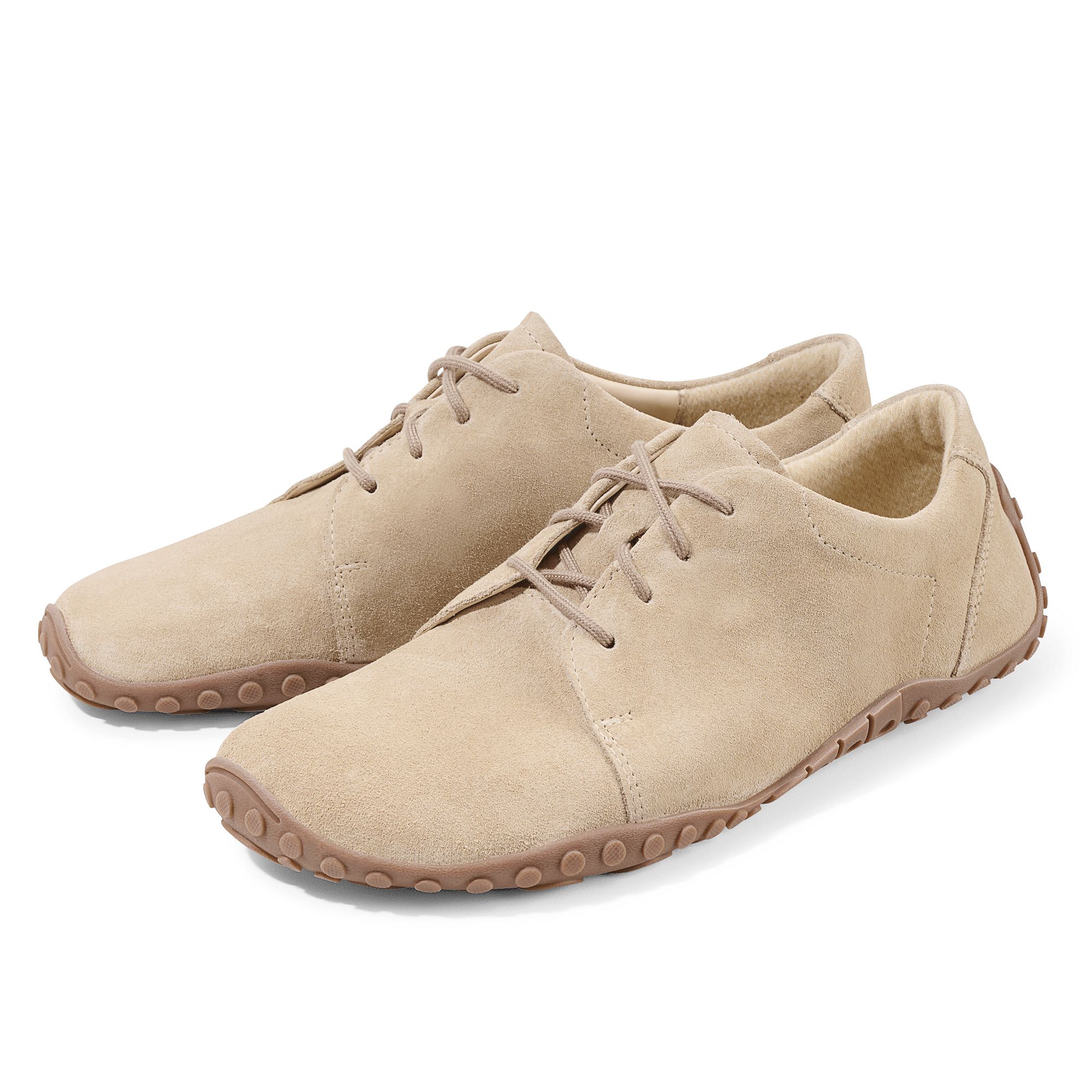 Zwei beigefarbene Schnürschuhe. Obermaterial aus Wildleder, braune Sohle. Seitliche Ansicht.
