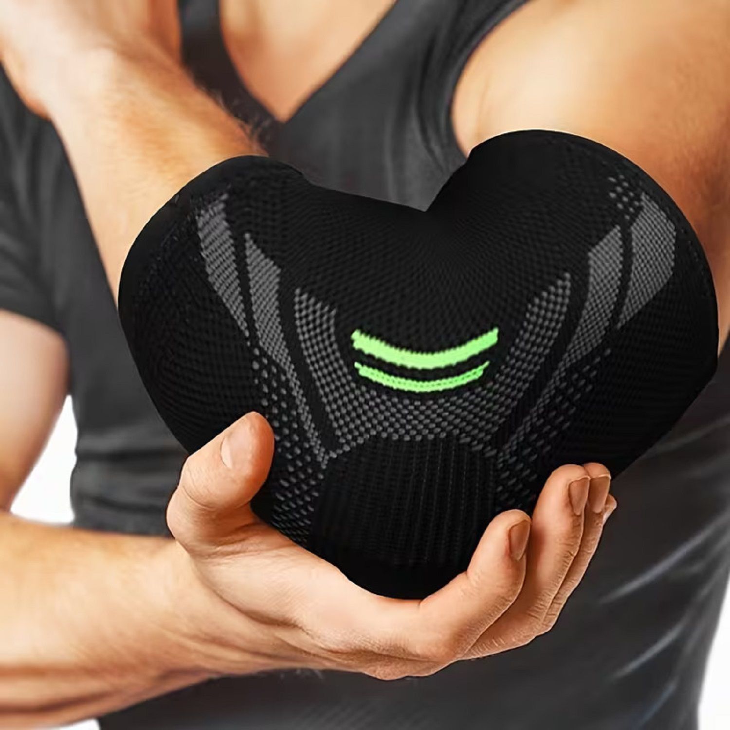 Person trägt schwarze Ellenbogenbandage. Bandage am Arm. Grünliche Akzente.