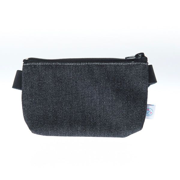 Dunkelblaue Jeans-Tasche mit Reißverschluss und schwarzem Bauchband. Kleines Etikett an der Seite.