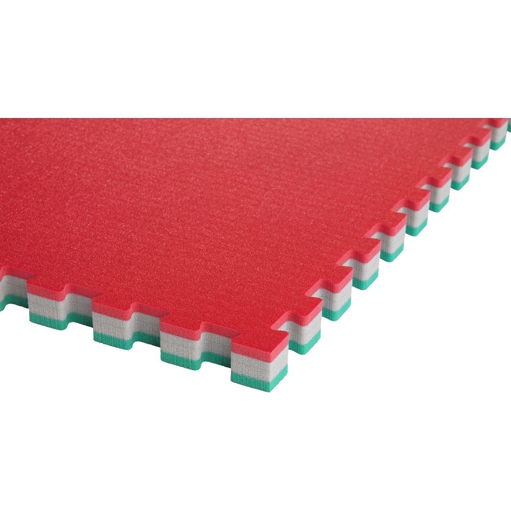 Nahaufnahme einer roten Judomatte. Die Matte hat ein Puzzle-Design mit grünen und weißen Kanten.
