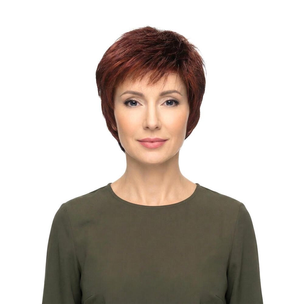 Kurzhaarperücke in Rotbraun. Frontale Ansicht einer Frau mit der Perücke. Kurzer, fransiger Schnitt.