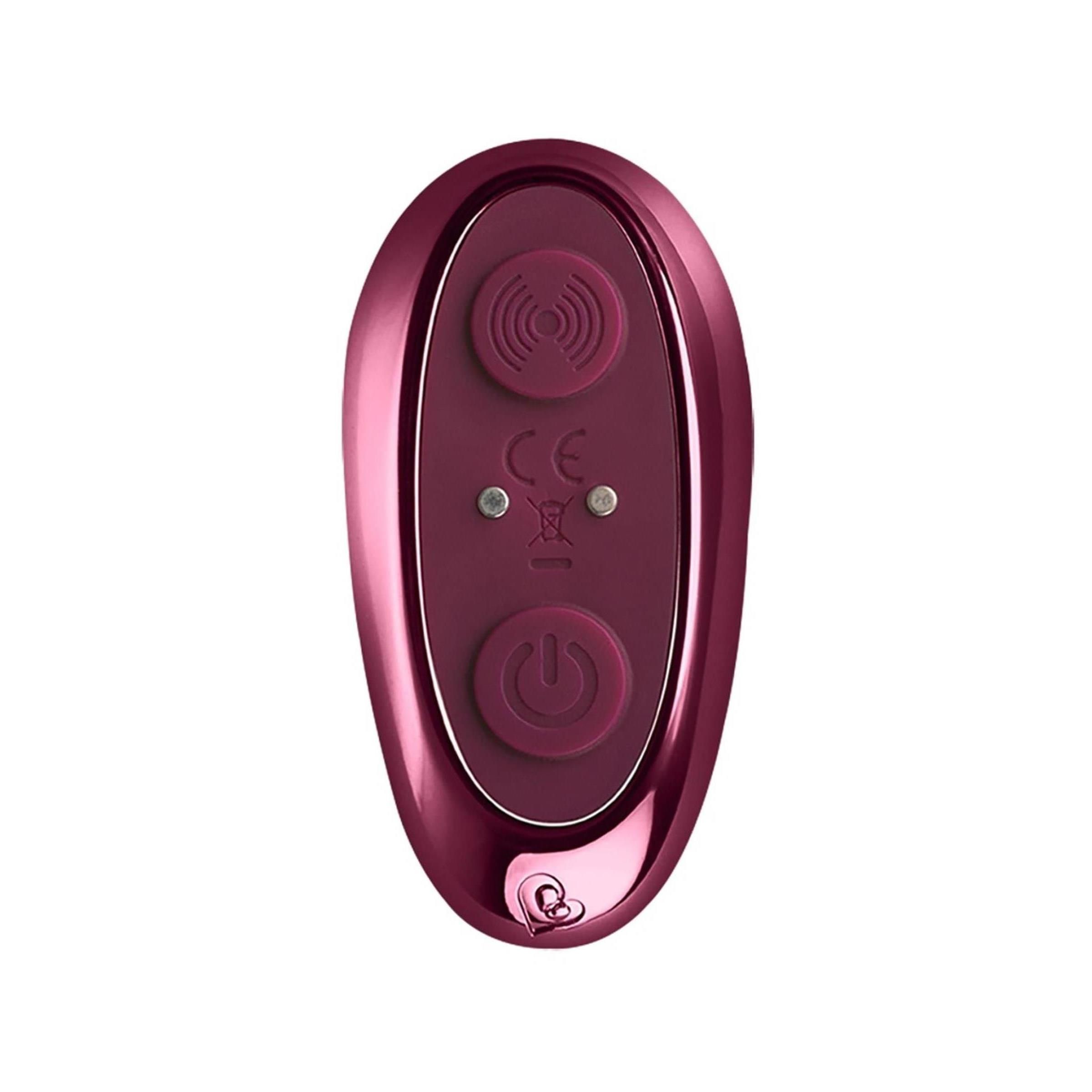 Dunkelrotes, ovales Produkt. Oberseite mit erhabenen Punkten. Fernbedienung mit Knöpfen.