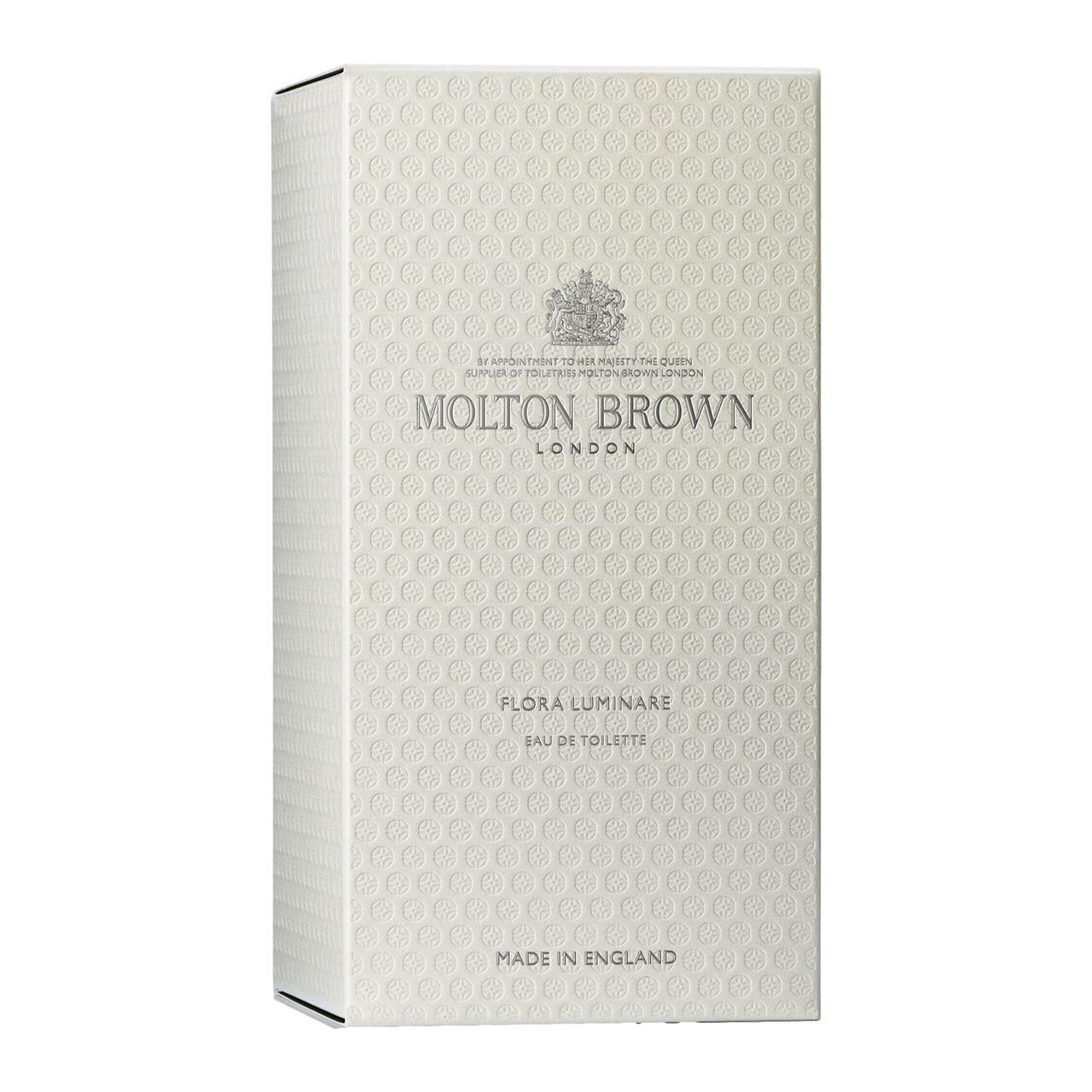 Weiße Verpackung mit geprägtem Muster. Aufschrift: Molton Brown London, Flora Luminare Eau de Toilette. Hergestellt in England.