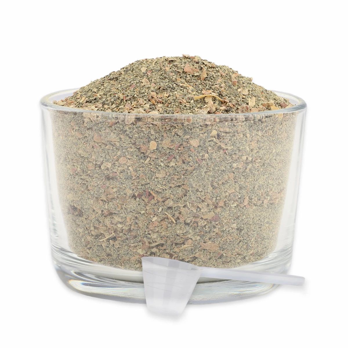 Glas mit grün-braunem Pulver, kleiner Messlöffel daneben.