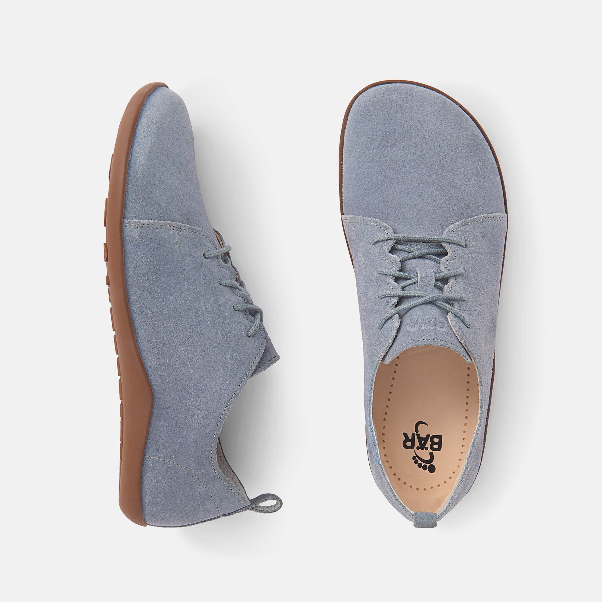 Hellblaue Schnürschuhe aus Wildleder. Braune Sohle. Schuh von der Seite. Zugschlaufe an der Ferse.