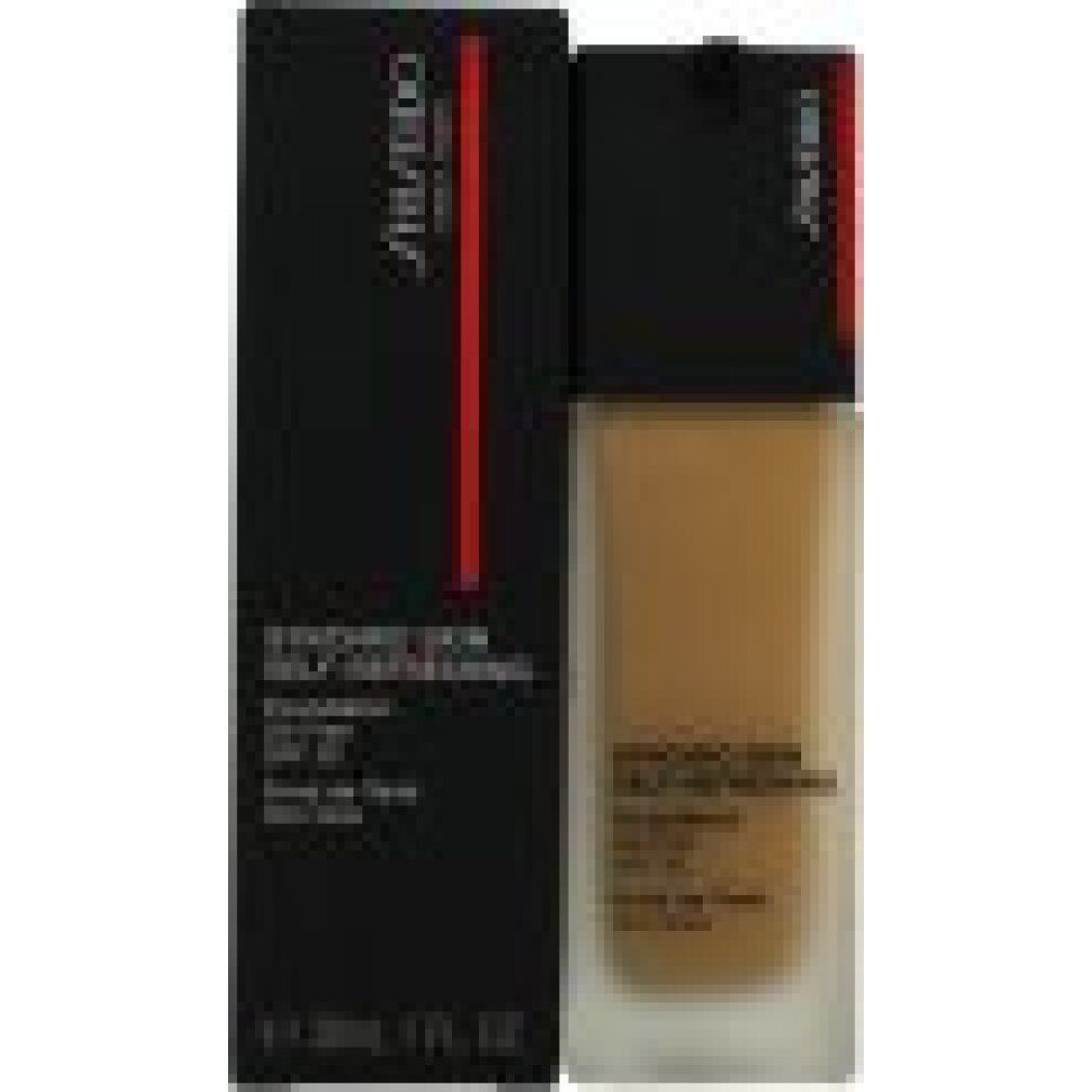 Make-up-Flüssigkeit und Verpackung. Schwarze Verpackung mit rotem Streifen und Produktnamen. Flasche mit schwarzem Deckel und Produkttext.