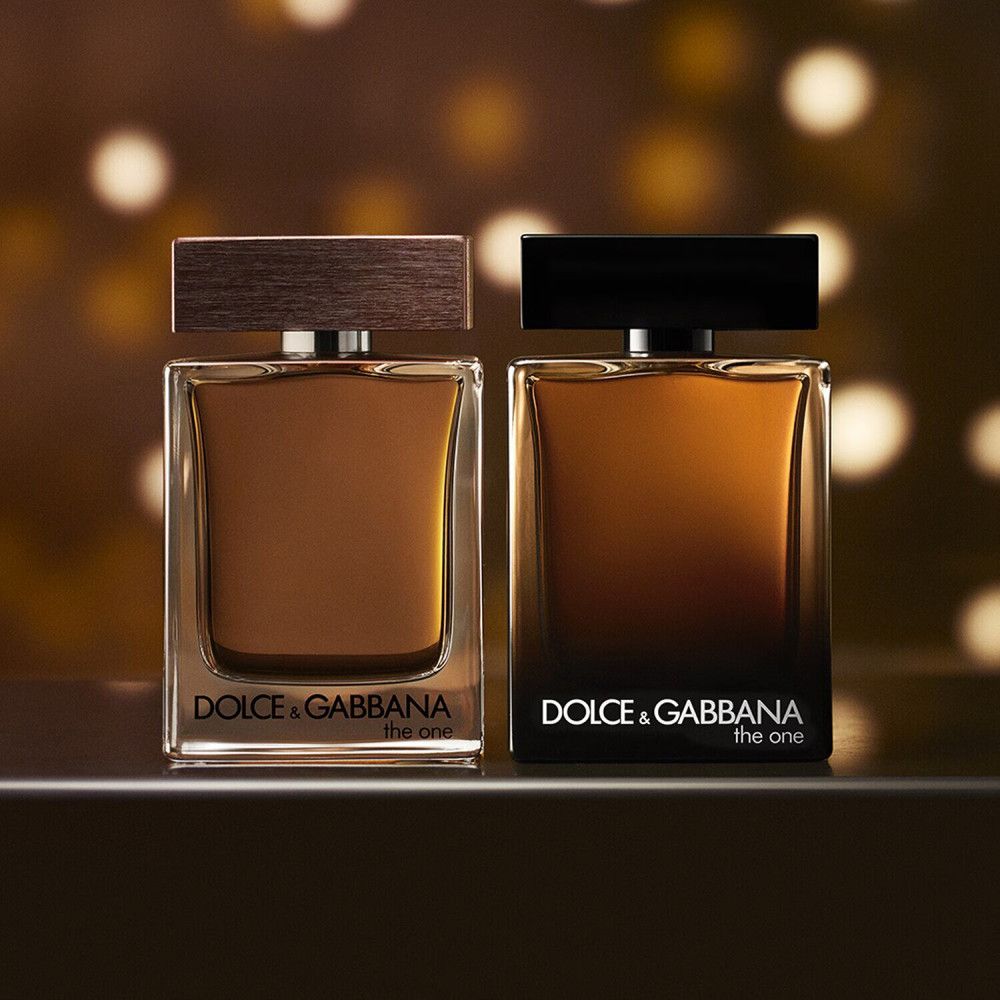 Zwei Flakons Dolce & Gabbana The One For Men. Beide Flakons sind rechteckig mit braunen Deckeln. Der Hintergrund ist unscharf.