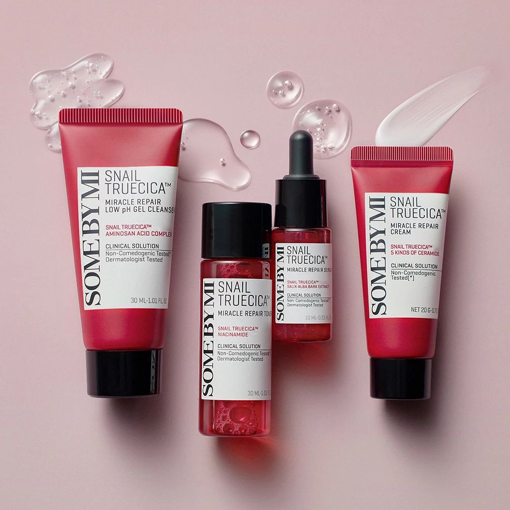 Vier Produkte in roten Tuben und Flaschen. Aufschrift: Snail TrueCICA. Einige Tropfen und eine Creme-Spur.