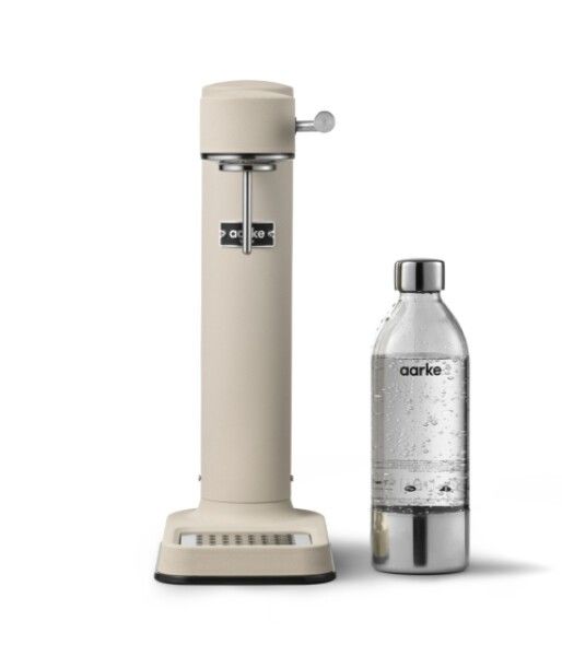 Beigefarbener Wassersprudler und Glasflasche. Sprudler mit Aarke-Logo. Flasche mit Metallboden und Deckel. Wasser sichtbar.