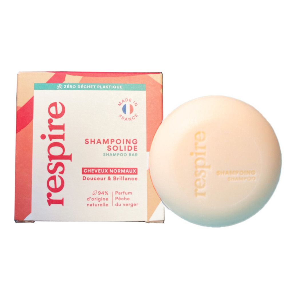 Runder Shampoo-Bar neben geöffneter Verpackung. "Respire"-Logo auf Bar und Verpackung. Text: "Shampoing Solide".