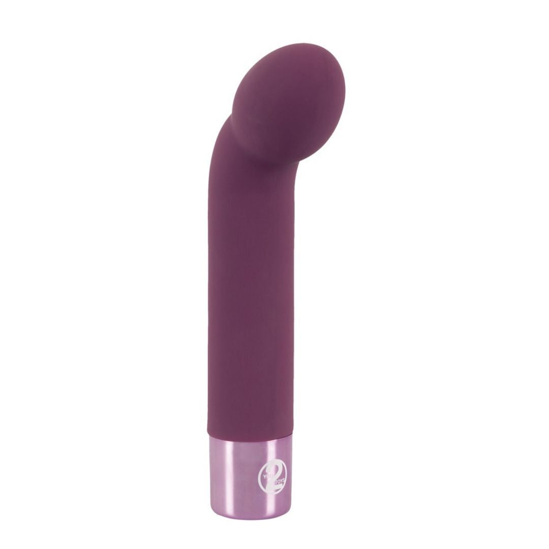 Lila Vibrator mit gebogener Spitze und silberfarbenem Sockel. Aufrecht stehend, vor weißem Hintergrund.