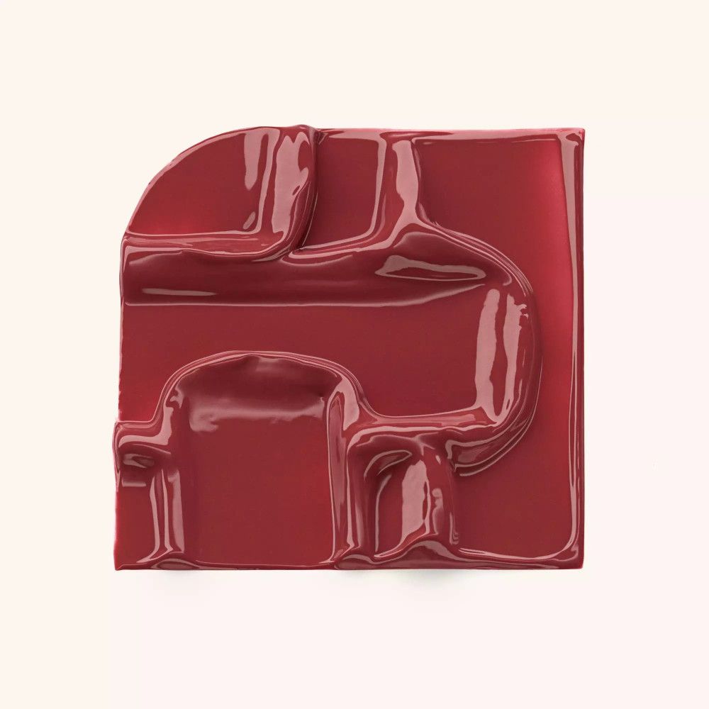 Roter, glänzender Farbklecks in quadratischer Form. Geformte Oberfläche.