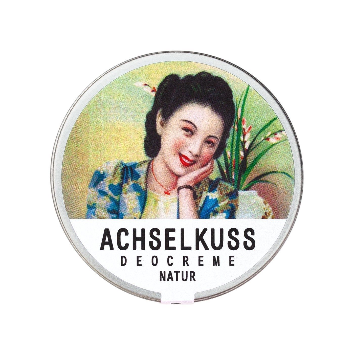 Runde Dose mit Deckel. Auf dem Deckel ist eine Frau abgebildet. Darunter steht "ACHSELKUSS DEOCREME NATUR".