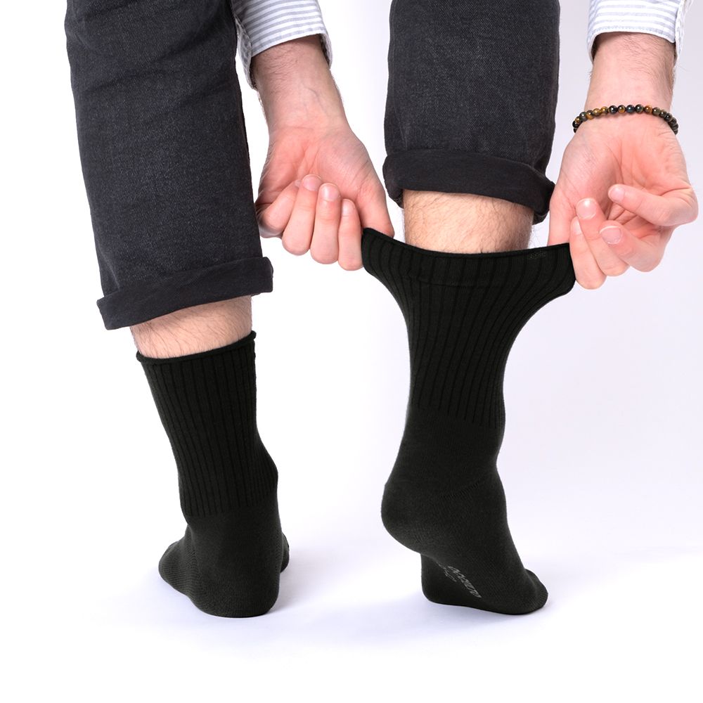 Schwarze Socken ohne Gummibund, eine Person dehnt den Bund einer Socke.