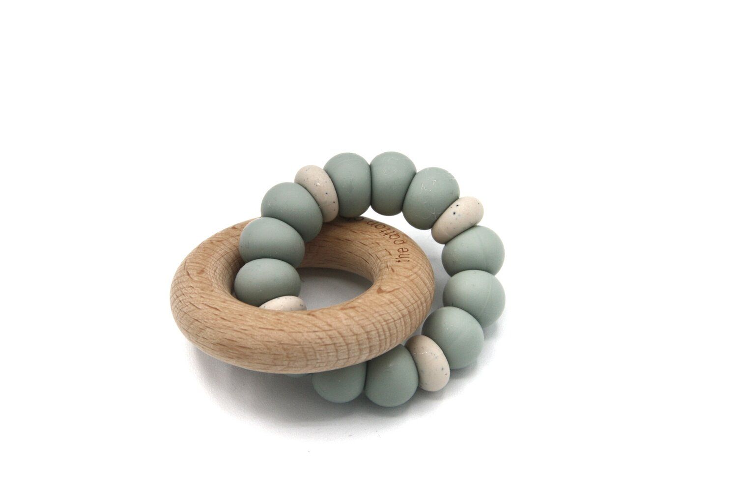 Beißring mit Holzring und grauen, kugelförmigen Elementen. Einige Elemente sind beige. Auf weißem Hintergrund.