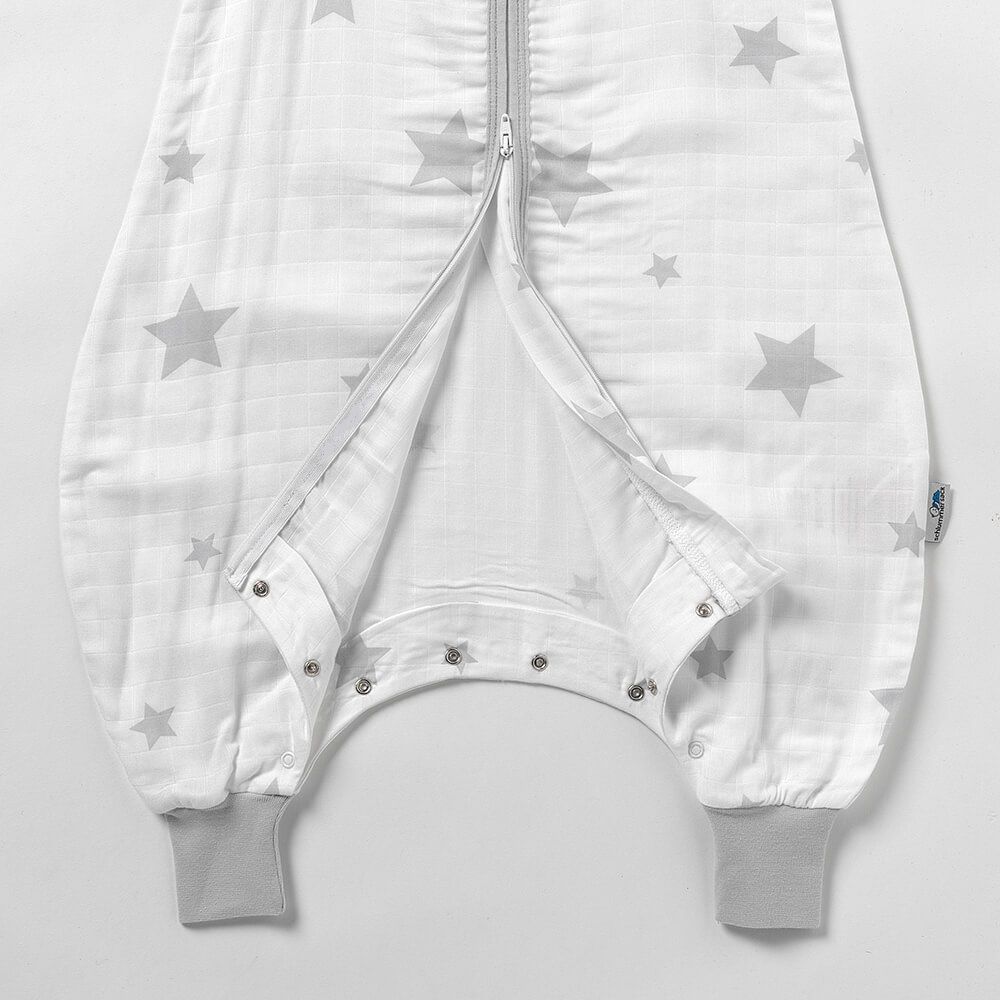 Detail des Baby-Schlafsacks mit Füßen. Reißverschluss geöffnet, Druckknöpfe. Graue Bündchen und Sterne.