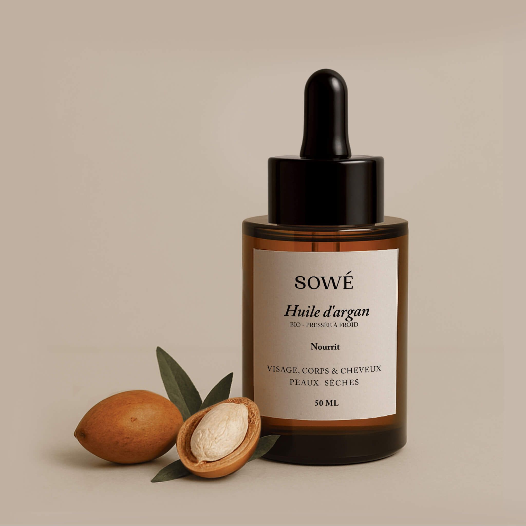 Braune Glasflasche mit Pipette. Etikett mit Text: SOWÉ, Huile d'argan, Nourrit, Visage, corps & cheveux, peaux sèches. Daneben Arganfrüchte.