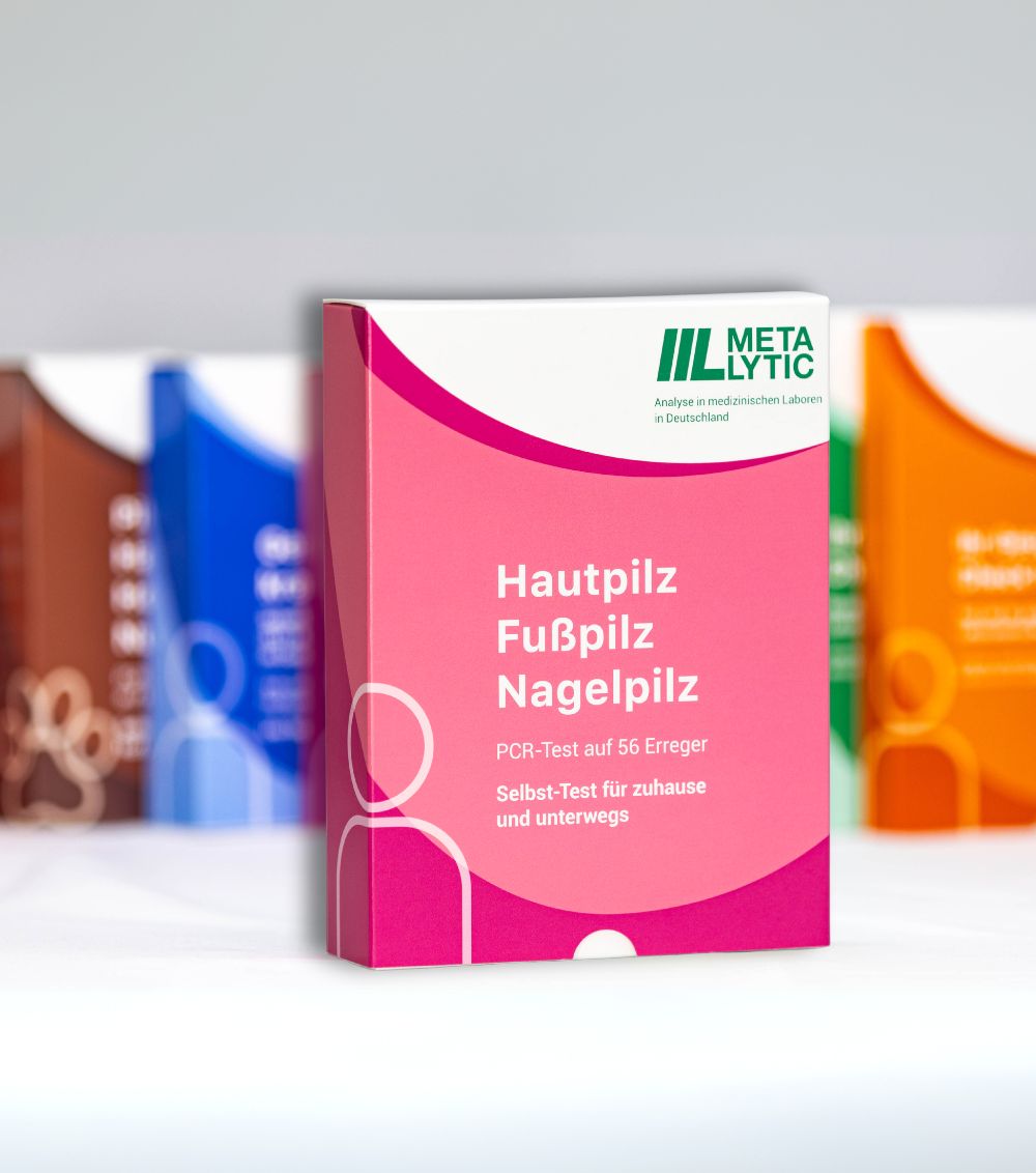 Mehrere Verpackungen des MetaLytic Pilztests. Rosa Verpackung im Vordergrund. Text: Hautpilz, Fußpilz, Nagelpilz. Logo: IIL MetaLytic.