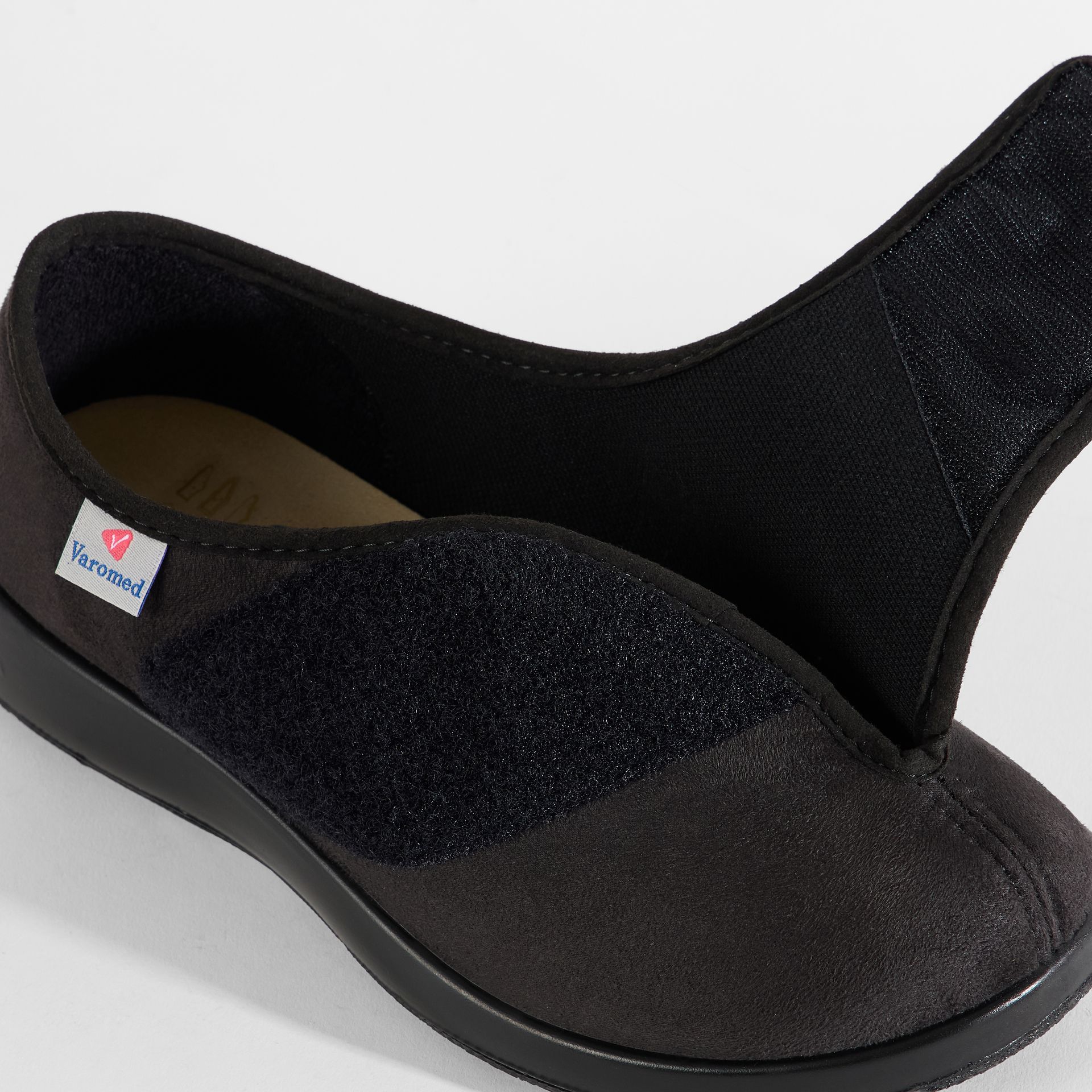 Braune Damenschuhe mit Klettverschluss und gemustertem Vorderteil.