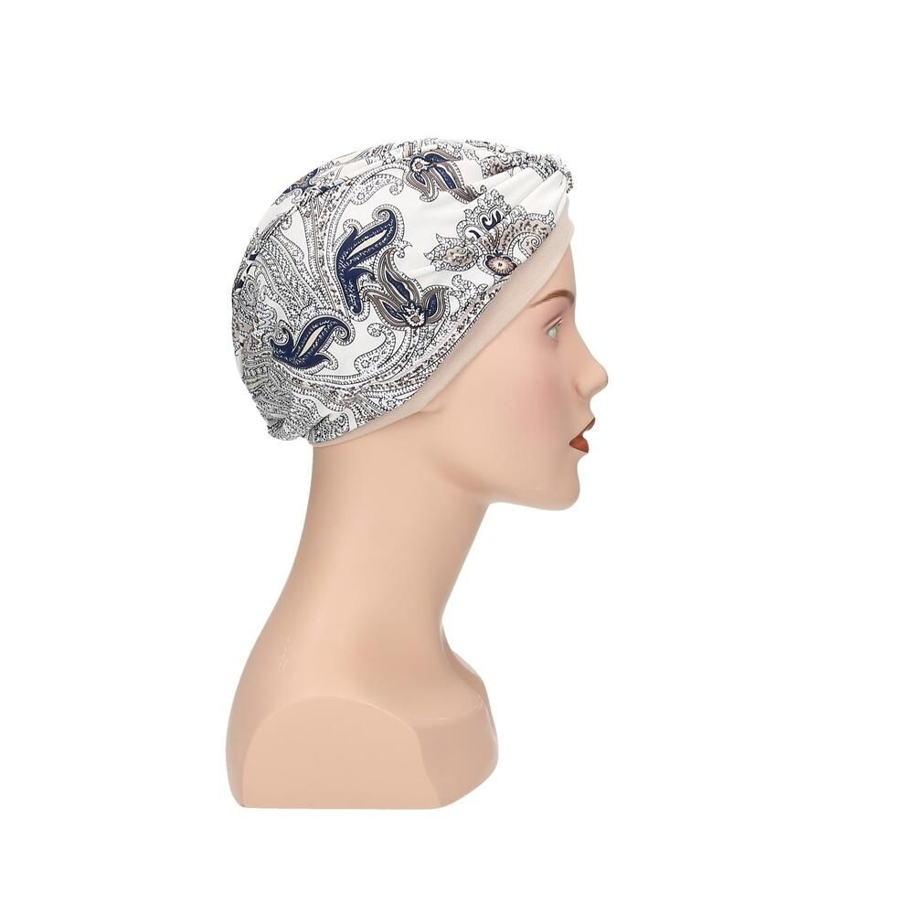 Turban Livia von Turbane. Beige Untertuch, bedruckter Stoff in Weiß, Blau und Grau. Auf einer Büste.
