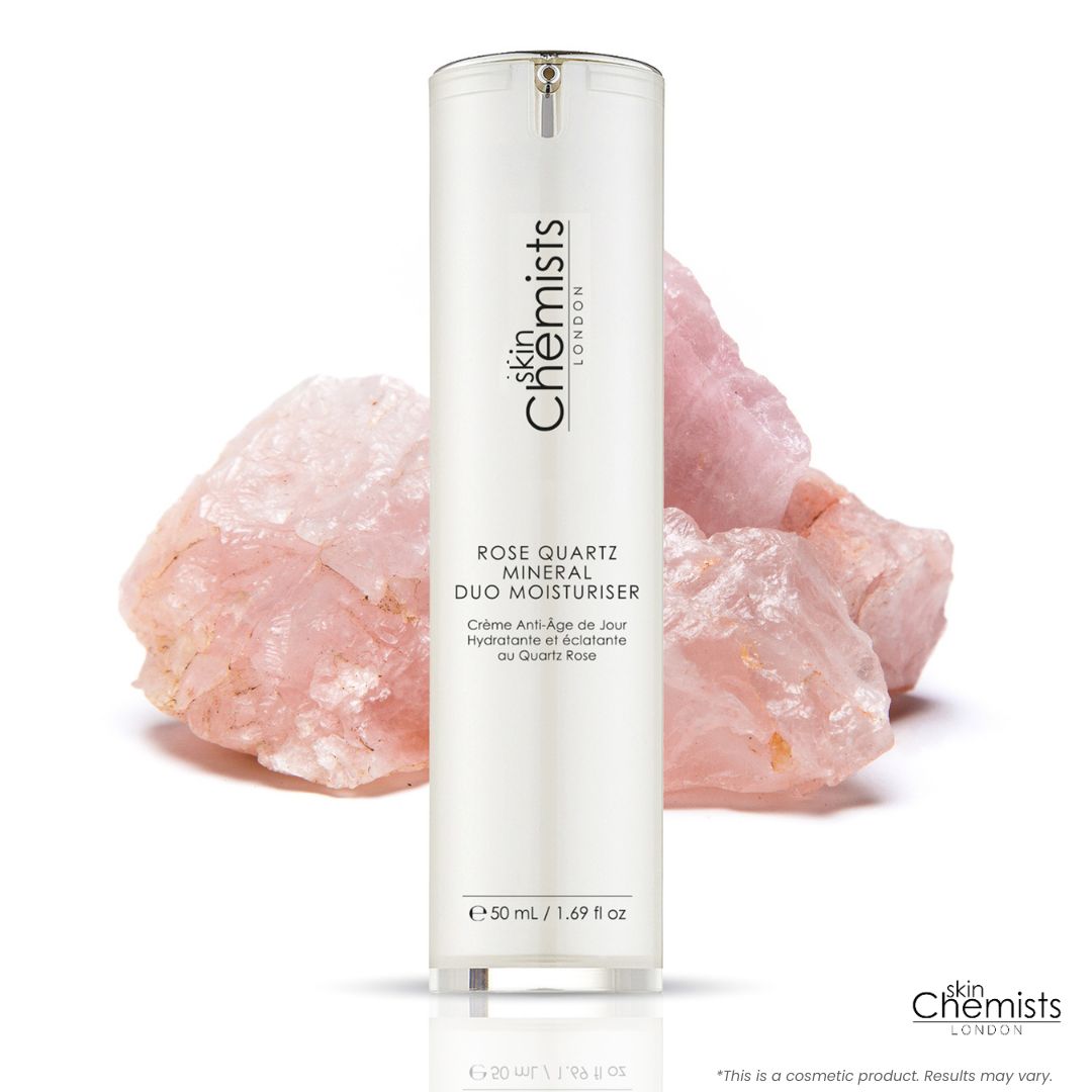 Flasche mit 'skinChemists LONDON'. Text: 'Rose Quartz Mineral Duo Moisturiser'. Rosa Quarzsteine im Hintergrund.