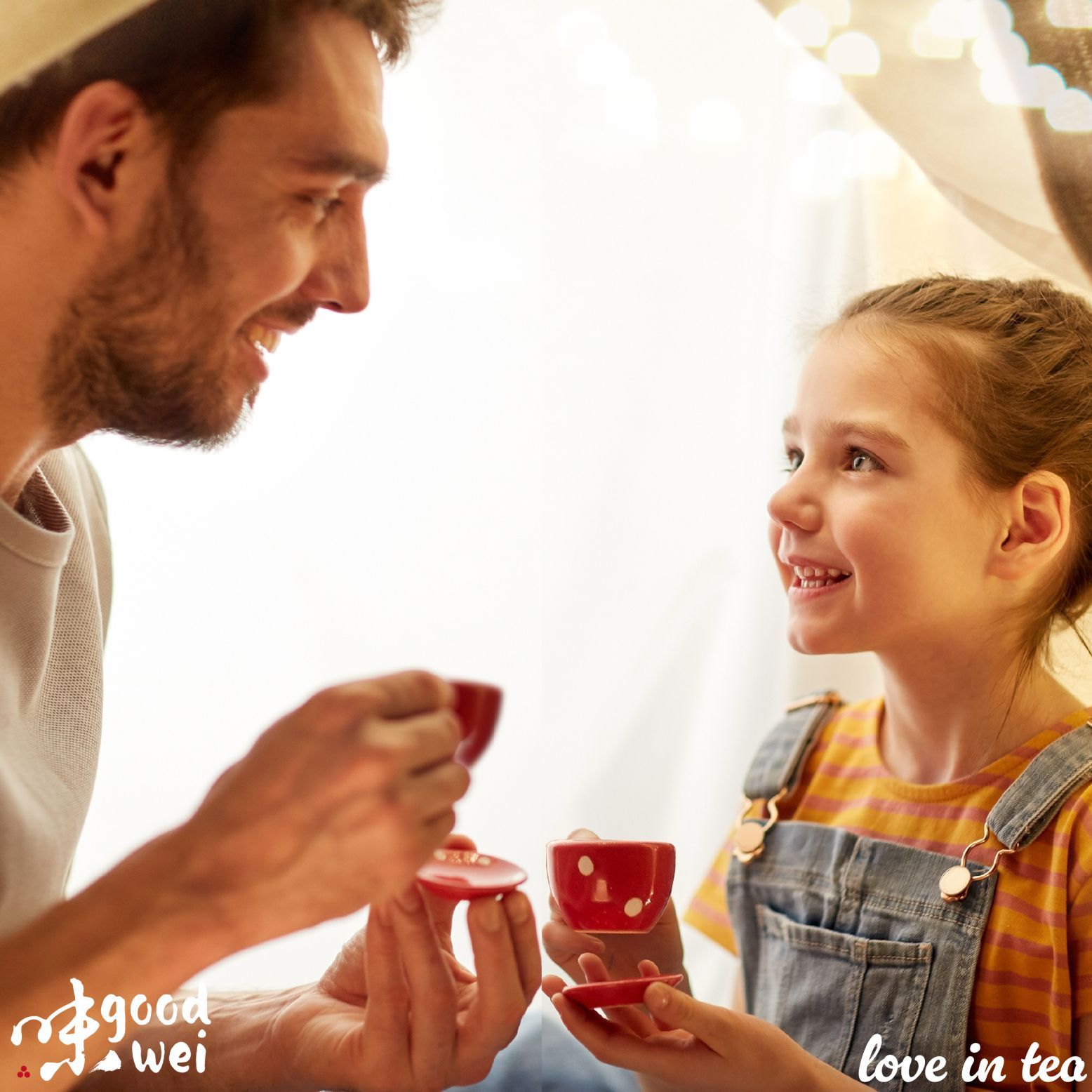 Mann und Mädchen trinken Tee aus roten Tassen. Logo Goodwei und Schriftzug 'love in tea'.