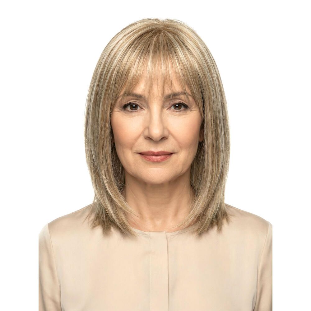 Blond gefärbte Perücke mit Pony. Mittellange, gestufte Haare. Frau mit hellem Oberteil. Frontale Ansicht.