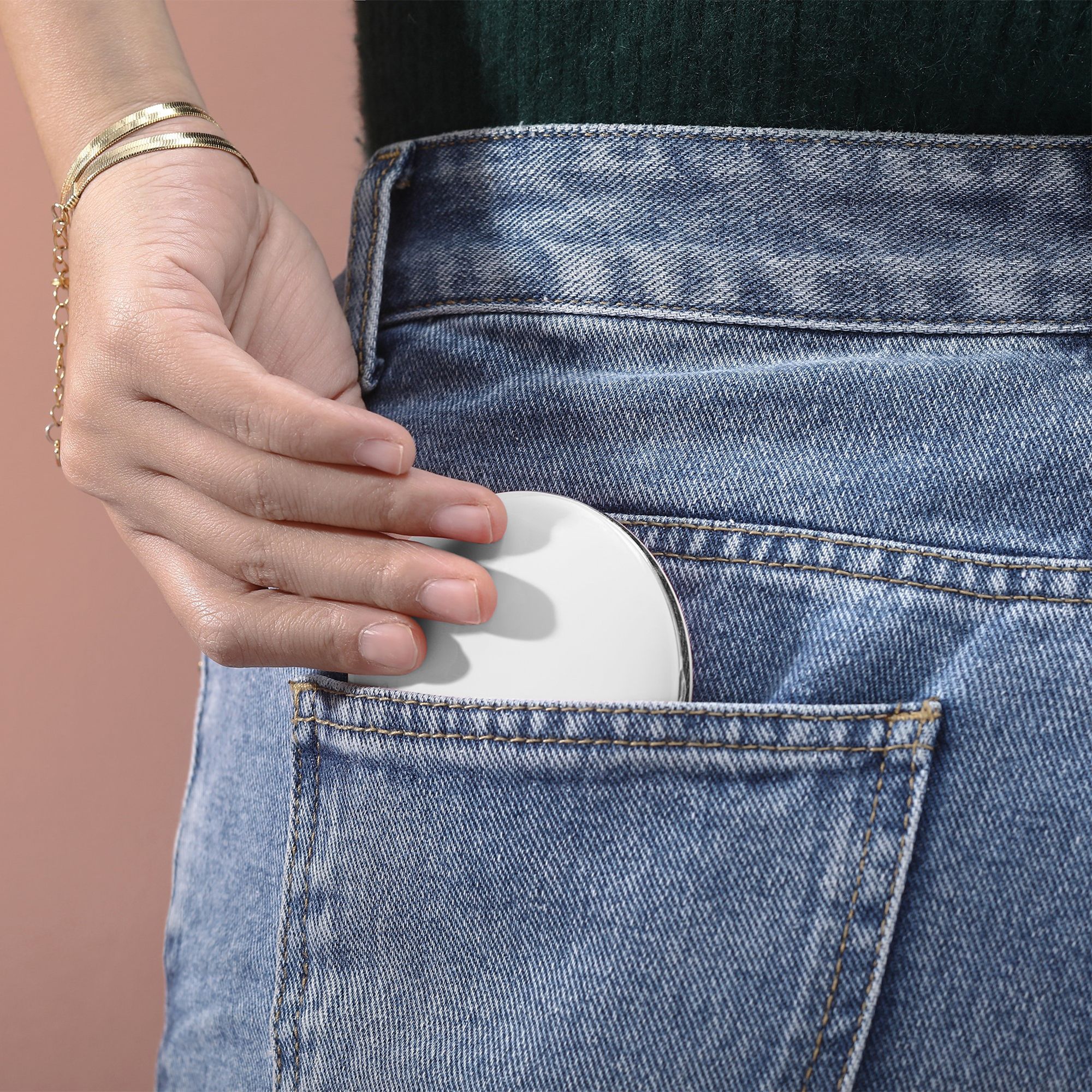 Weißer, ovaler Taschenspiegel in Jeans-Hosentasche. Silberfarbener Rand.
