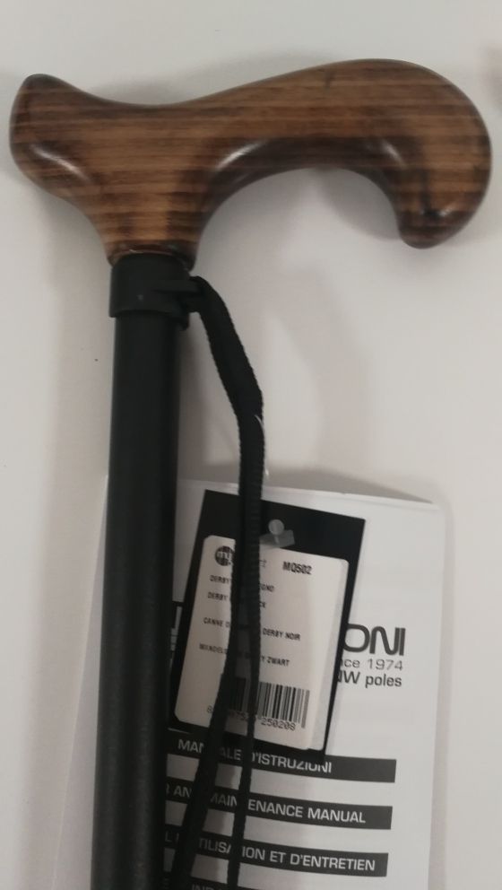 Gehstock mit Holzgriff und schwarzem Schaft. Handschlaufe. Anhänger mit Produktinformationen. Bedienungsanleitung.