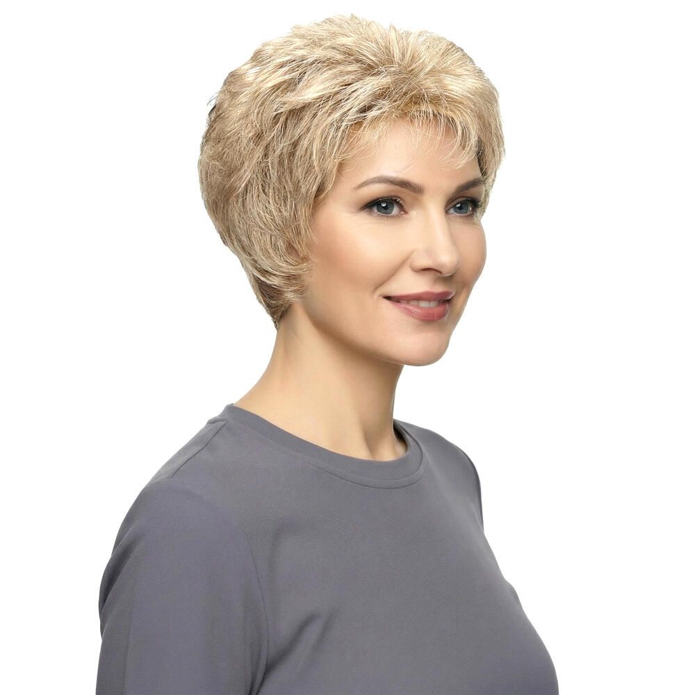 Blonde, gewellte Kurzhaarperücke. Frau mit grauem Shirt, leichtes Lächeln.