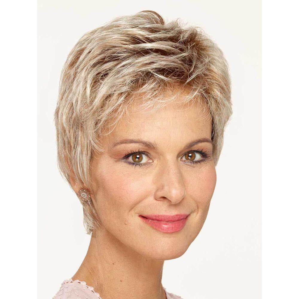 Kurzhaarperücke in Blondtönen. Frau mit Perücke, lächelnd. Ohrringe. Rosa Oberteil. Heller Hintergrund.