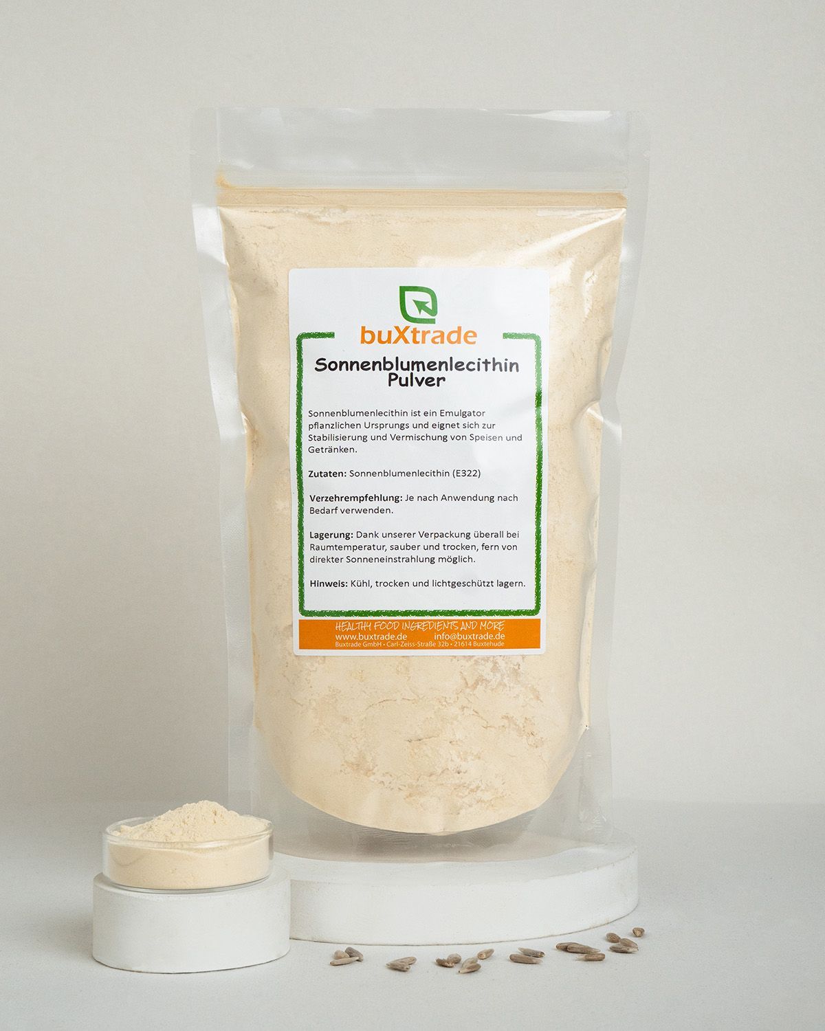 Verpackung mit buXtrade Sonnenblumenlecithin Pulver, daneben eine Schale mit Pulver und Sonnenblumenkernen.