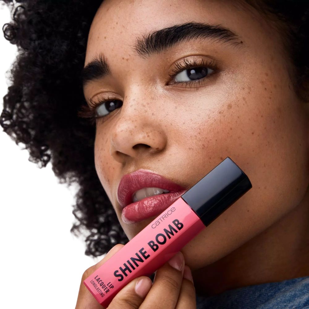 Frau mit rosa Lippenstift. Aufschrift: Catrice Shine Bomb Lip Lacquer.