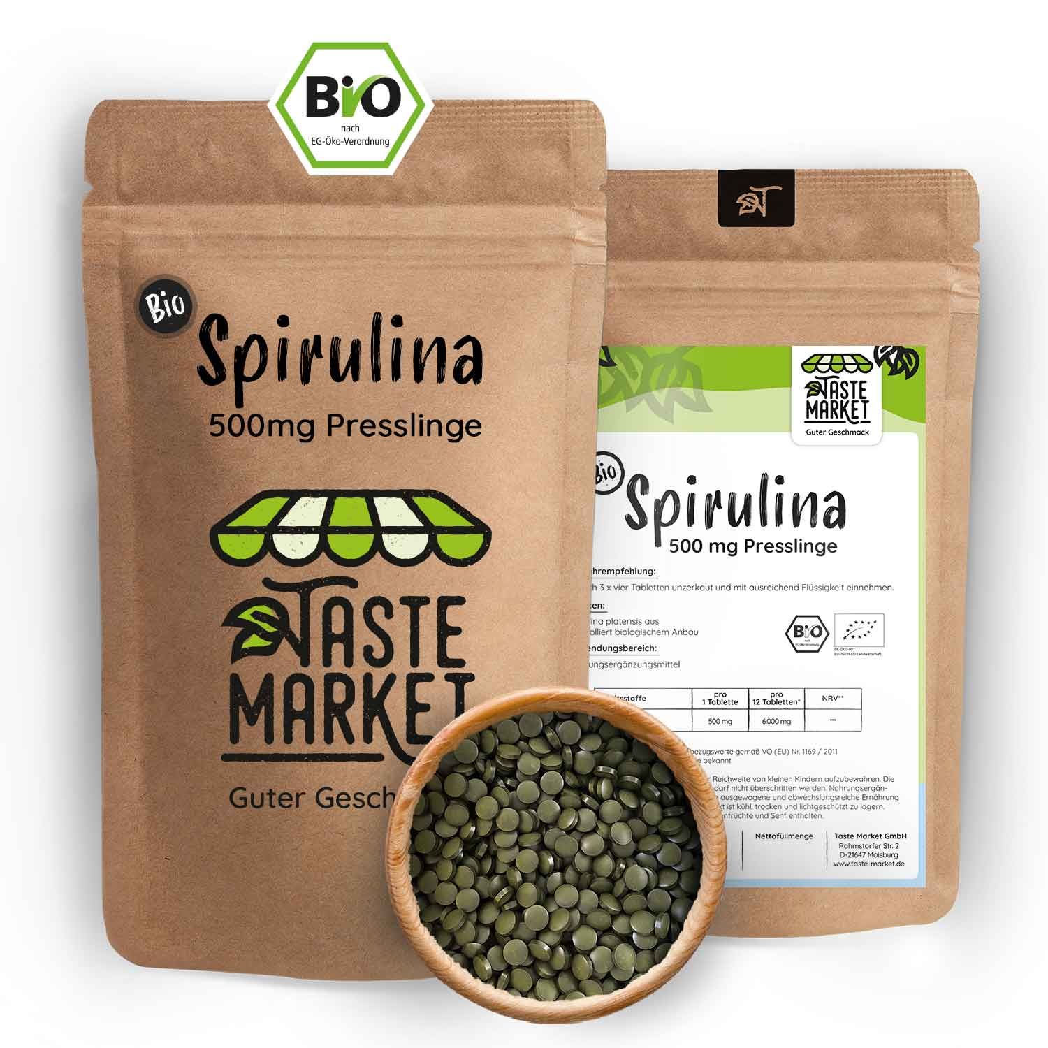 Zwei braune Papierverpackungen mit grünen Etiketten. Text: Bio Spirulina 500 mg Presslinge. Daneben eine Holzschale mit grünen Presslingen.