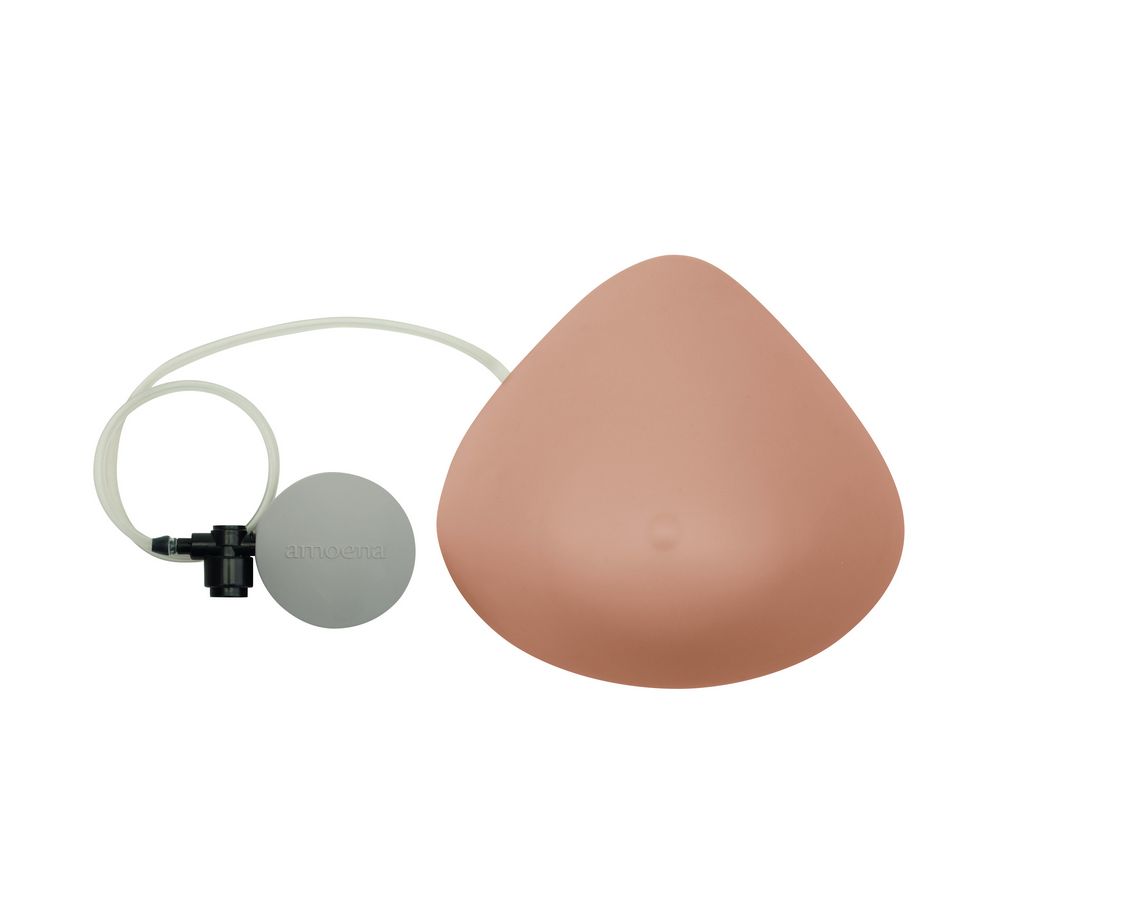 Brustprothese, dreieckig, hautfarben. Mit Pumpe und Schlauch. Pumpe mit Logo.