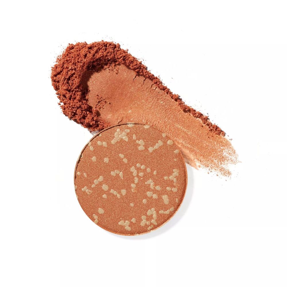 Runder, orangefarbener Lidschatten mit hellen Punkten und einem Farbabstrich. Auf weißem Hintergrund.