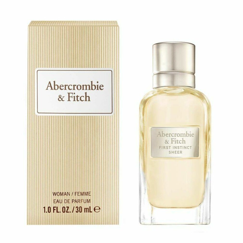 Parfümflasche und Karton. Auf dem Etikett steht "Abercrombie & Fitch First Instinct Sheer". Auf dem Karton steht "WOMAN / FEMME".