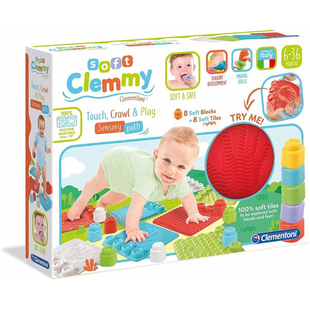 Verpackung mit Clemmy-Spielmatte. Enthält weiche Blöcke, Fliesen und einen roten Ball. Baby krabbelt auf der Matte. Text: Soft Clemmy, 6-36 Monate.