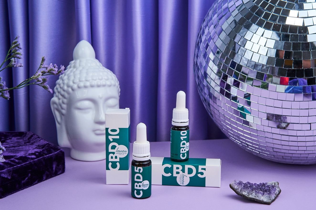 Mehrere Flaschen und Verpackungen mit grüner Etikettierung. Aufschriften CBD10 und CBD5. Dekoration.