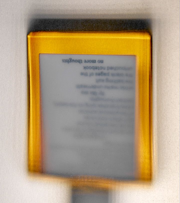 Gelbes Rechteck mit Text. Unschärfe. Text: no more thoughts, etc. Aufschrift: notebook.