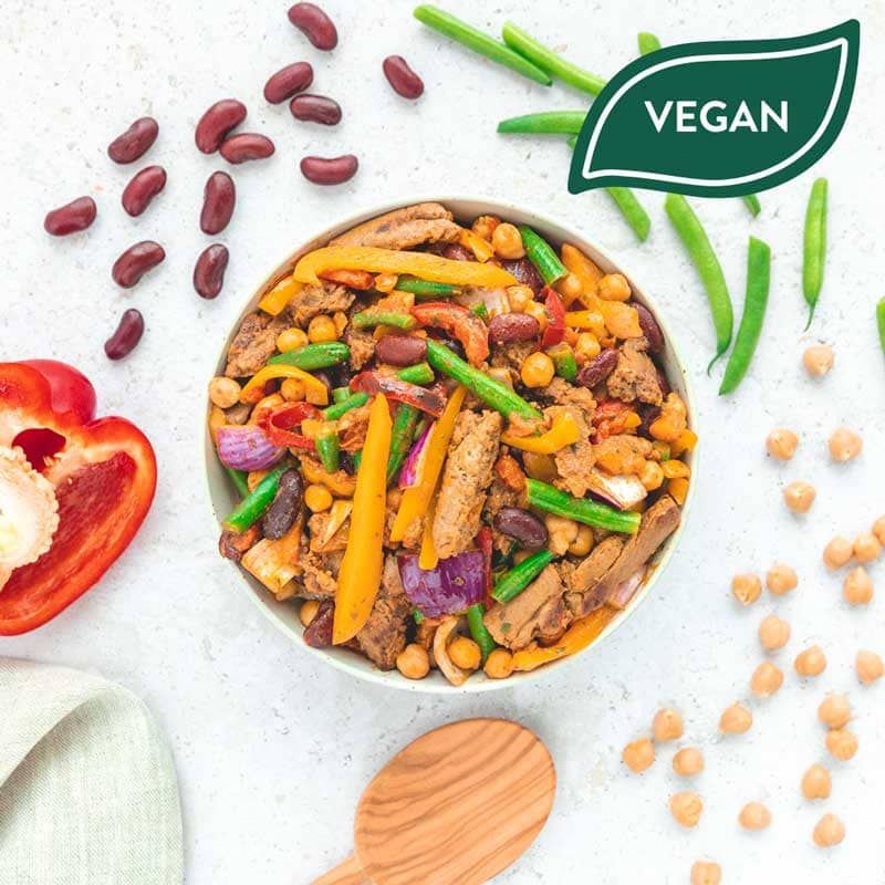 Veganes Gericht mit Bohnen, Gemüse und Sojabohnen. Draufsicht. Auf hellem Untergrund. Vegan-Siegel.