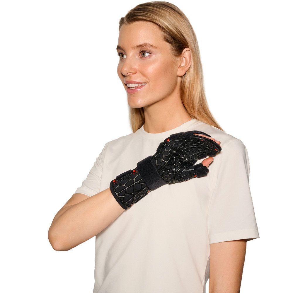 Frau trägt eine schwarze Handgelenkorthese mit Gittermuster am linken Arm.
