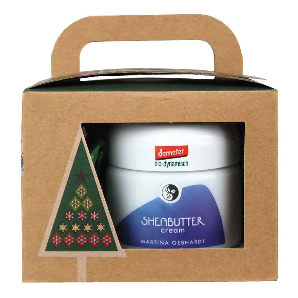 Creme-Dose in Geschenkbox. Aufschrift: Sheabutter Cream, Martina Gebhardt. Demeter-Siegel. Karton mit Weihnachtsbaum-Motiv.