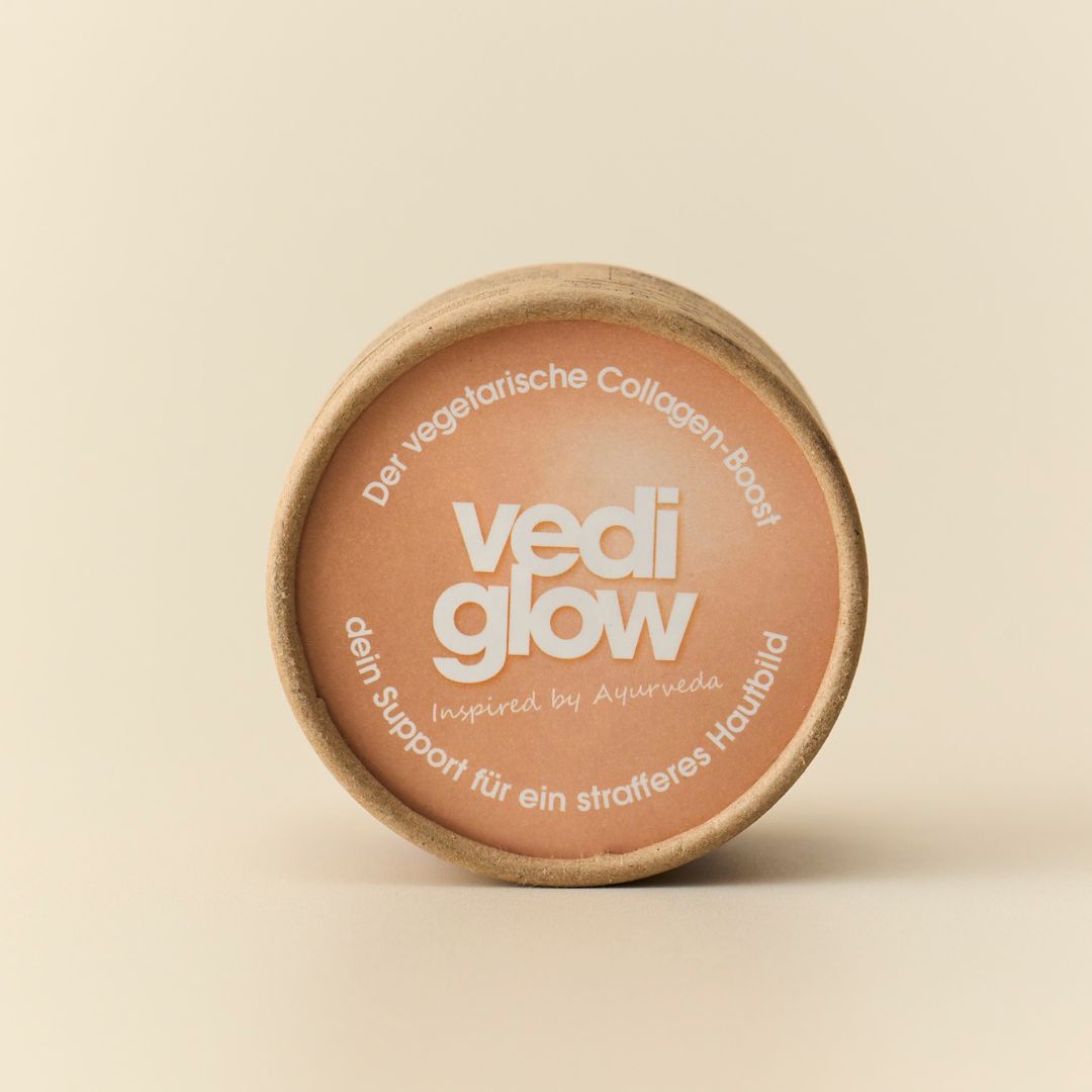 Runde Pappdose mit Aufdruck. Aufschrift: vedi glow, Collagen-Boost, inspiriert von Ayurveda.