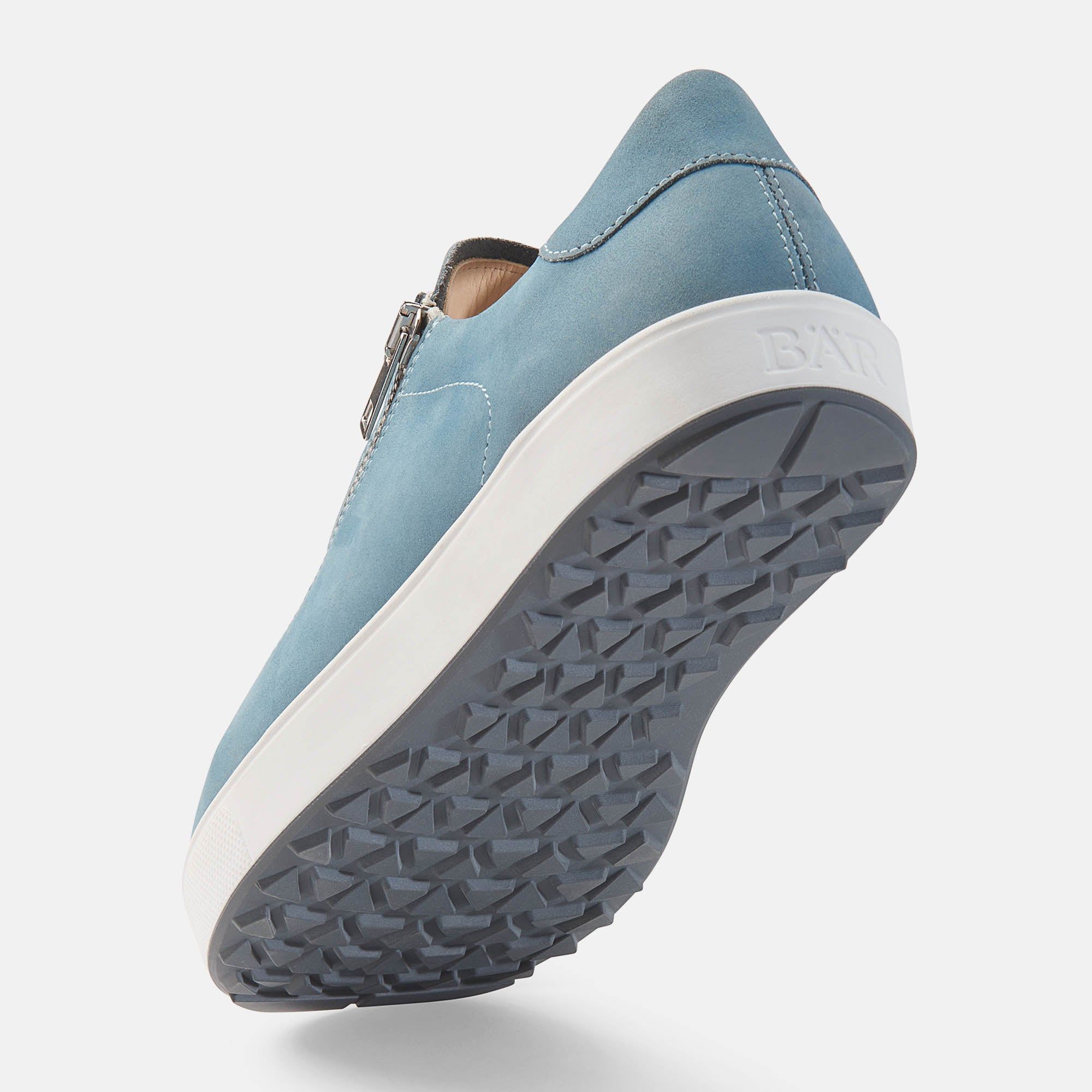 Hellblauer Schuh mit weißer Sohle. Reißverschluss. Unterseite der Sohle mit Profil.