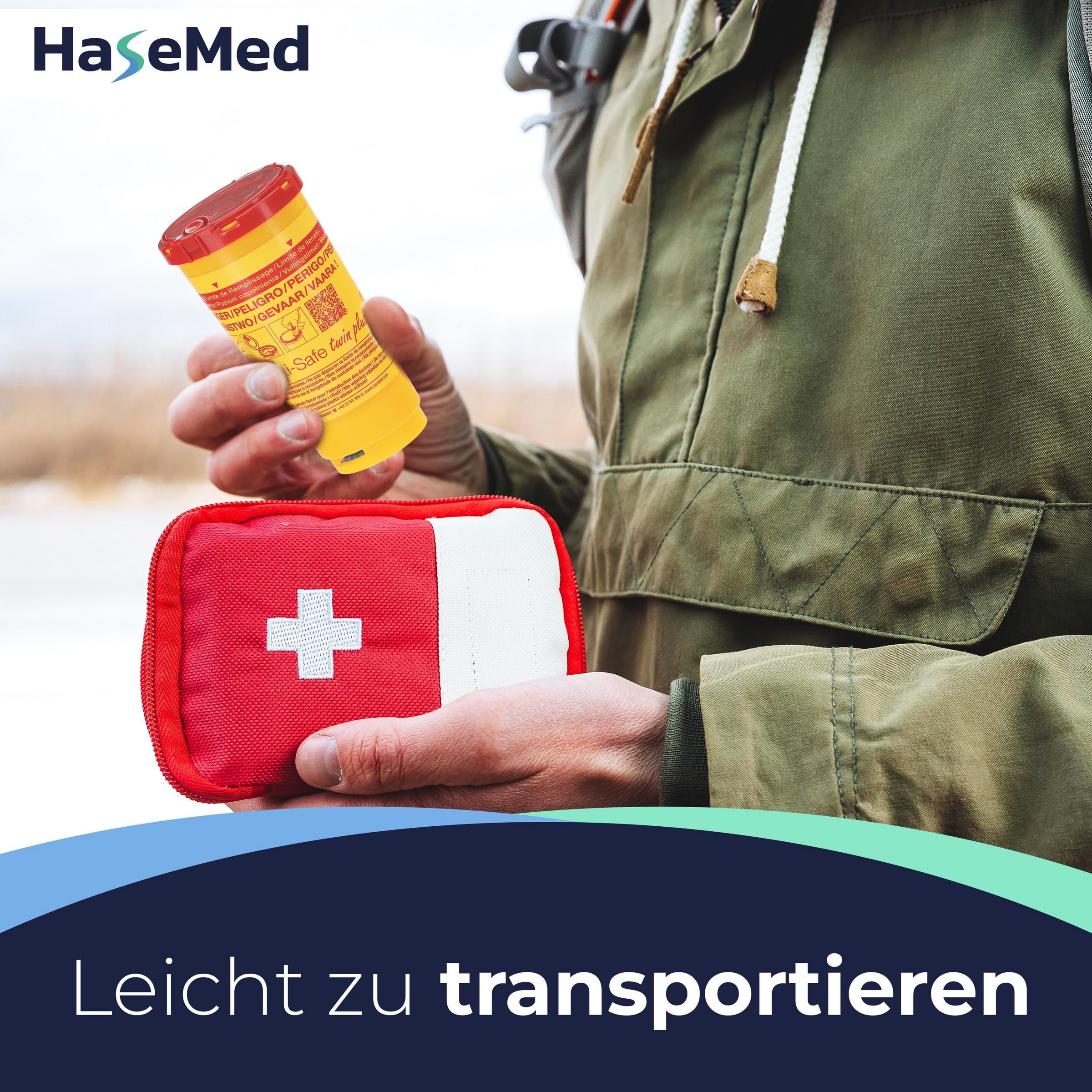 Gelber Kanülensammler mit rotem Deckel. In der Hand gehalten. Rotes Erste-Hilfe-Set daneben.