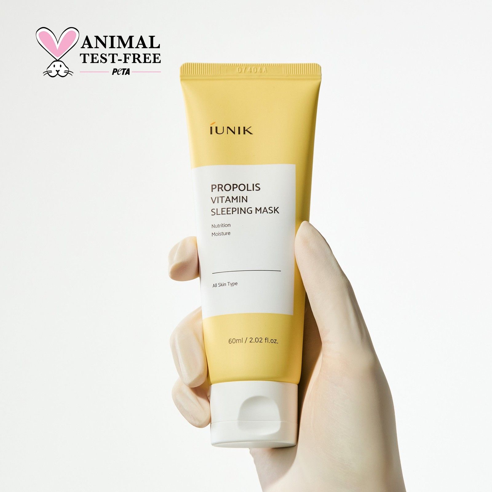 Hand hält iUNIK Propolis Vitamin Sleeping Mask Tube mit PETA-Siegel.