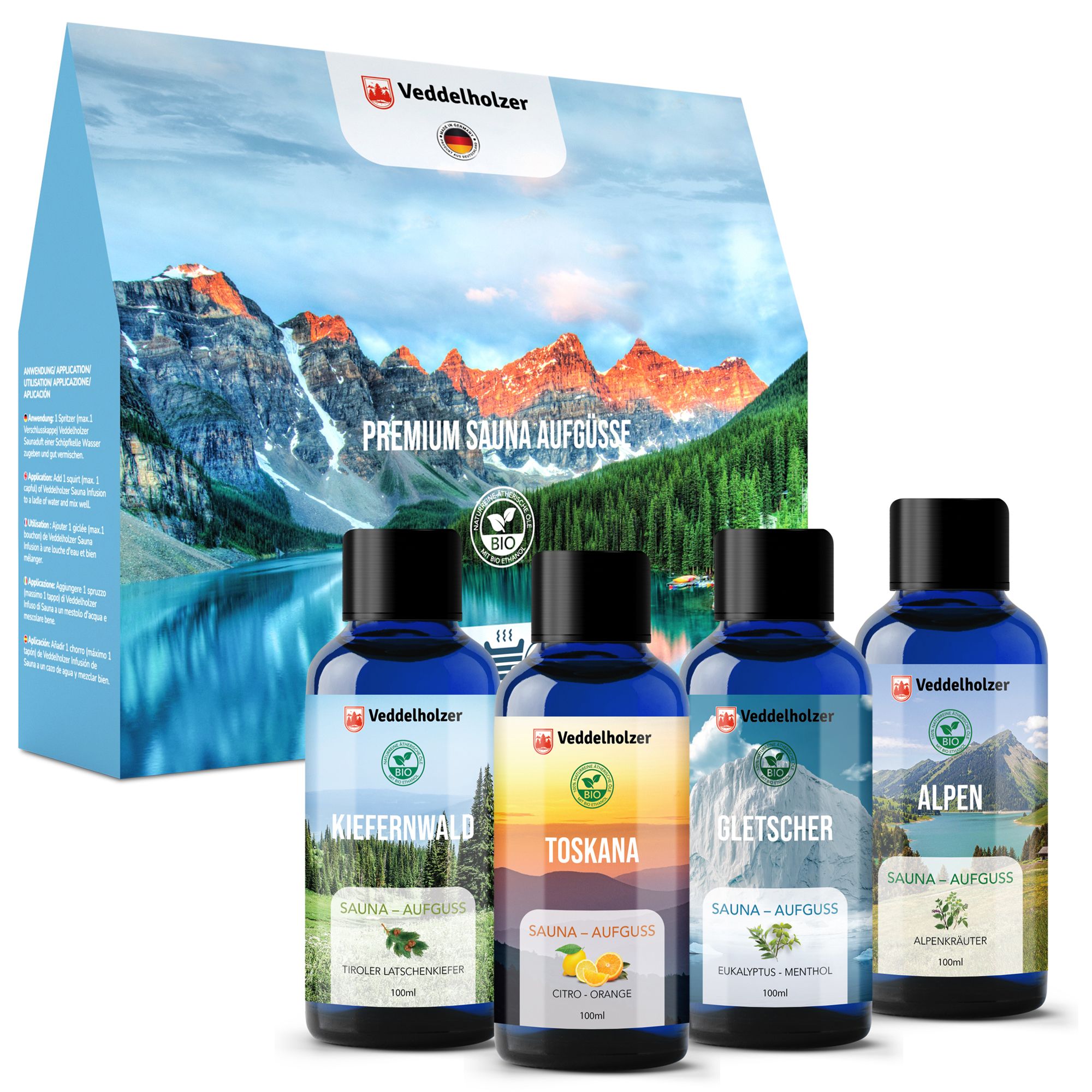 Set mit vier Saunaaufgüssen in blauen Flaschen. Verpackung mit Berglandschaft. BIO-Siegel und Veddelholzer Logo.
