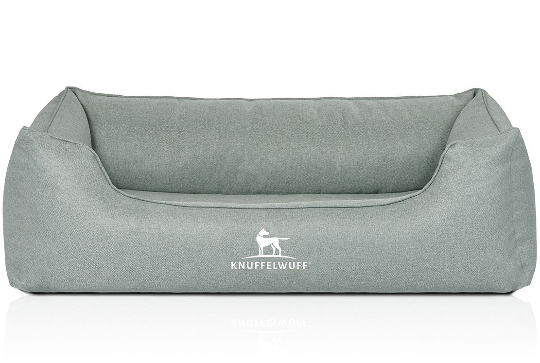 Hellgraues orthopädisches Hundebett Luisa. Rechteckige Form mit erhöhten Seiten und Rückwand. Weißes Logo "Knuffelwuff" vorne.